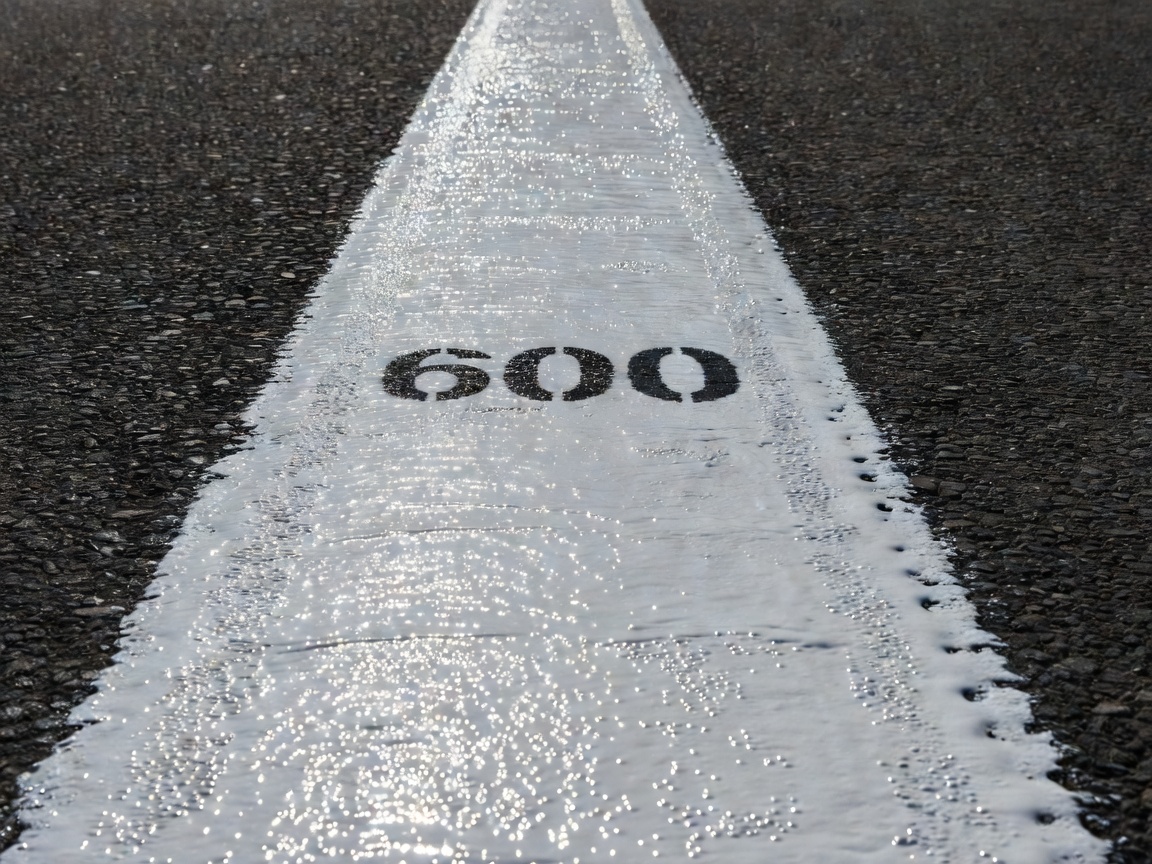 Close up of a newly painted white thermoplastic lane marking with glass beads for reflectivity